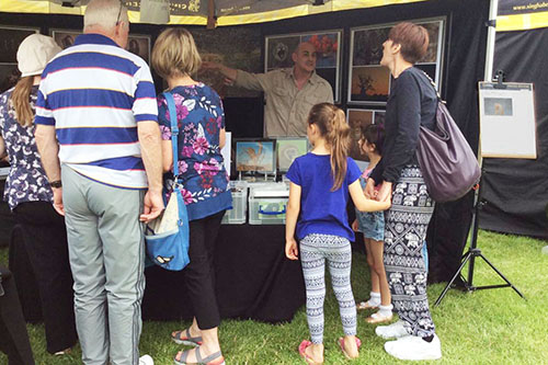 people listing to photographer Ashley Vincent speaking at an outdoor event