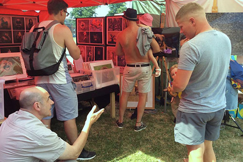 wildlife photographer Ashley Vincent talking to a young girl and her father at an outdoor event