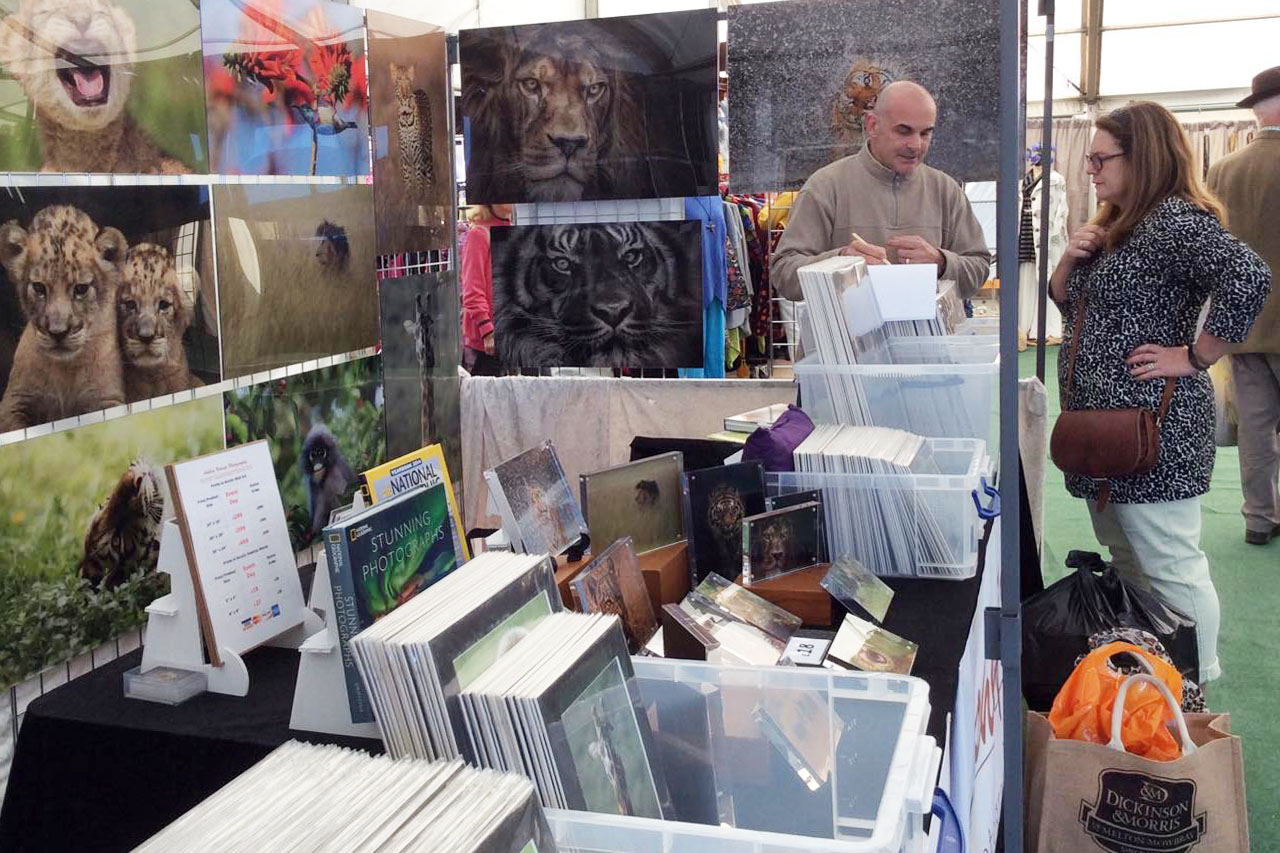 lady customer paying for a wildlife print at Ashley Vincent’s event stand