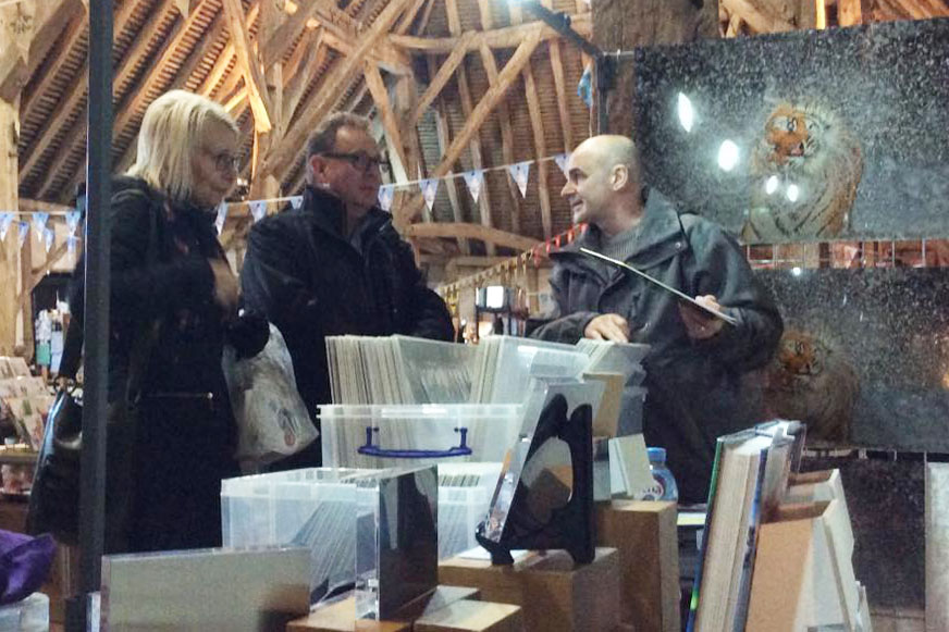 married couple talking to photographer Ashley Vincent at his event stand