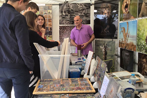 customers engaging with Ashley Vincent at his picture display gazebo at the food and drink festival in Clissold Park