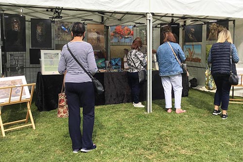 customers engaging with wildlife photographer ashley vincent at his stand at the end of summer market in Tenterden