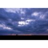 animalscape of a seemingly very small elephant walking across the horizon and silhouetted against a colourful and cloud-filled Kenyan sky at sunset